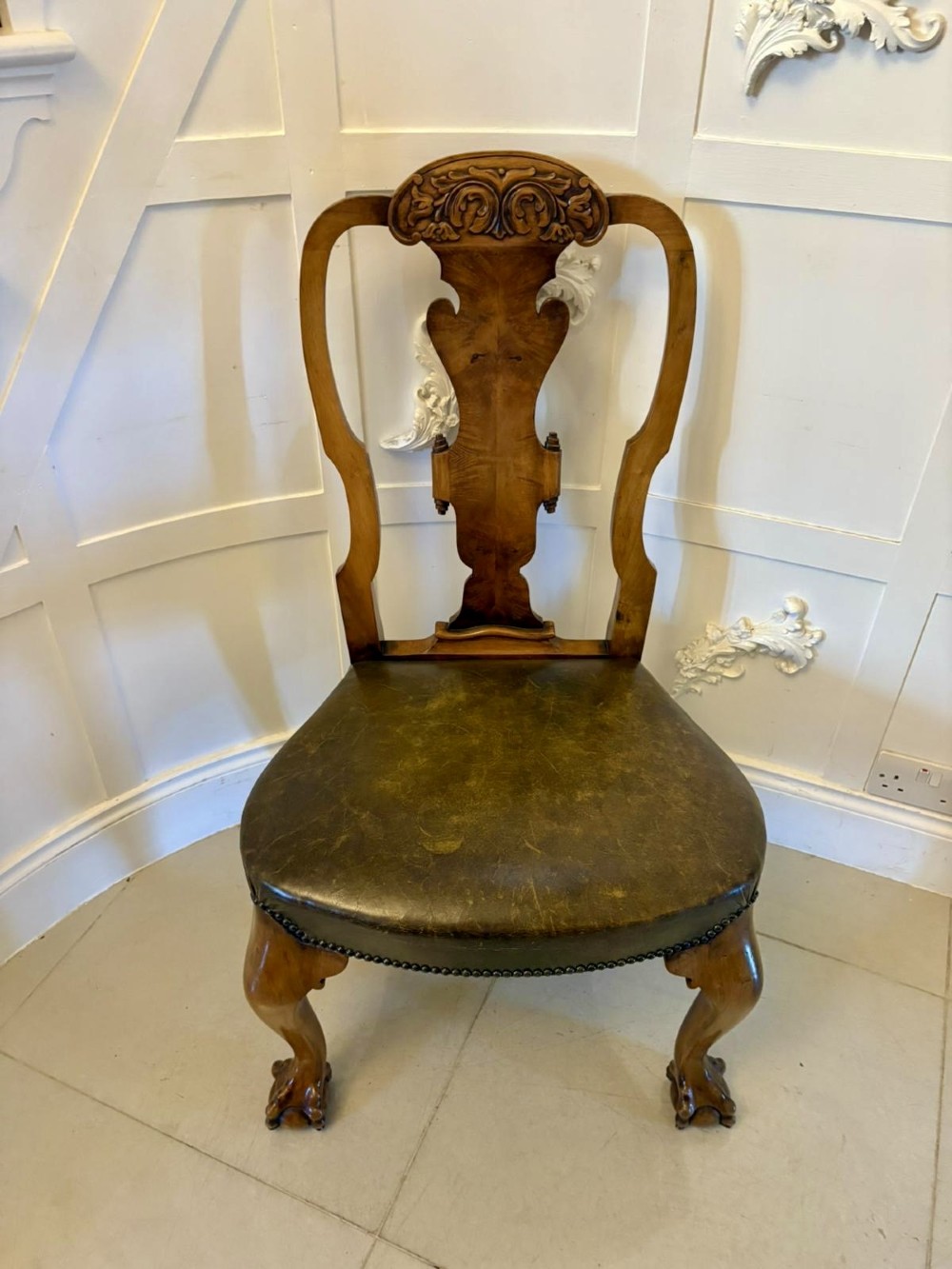 A set of six carved walnut dining chairs featuring decorative back splats, leather seats with brass studs, cabriole legs, and ball and claw feet. View XIV