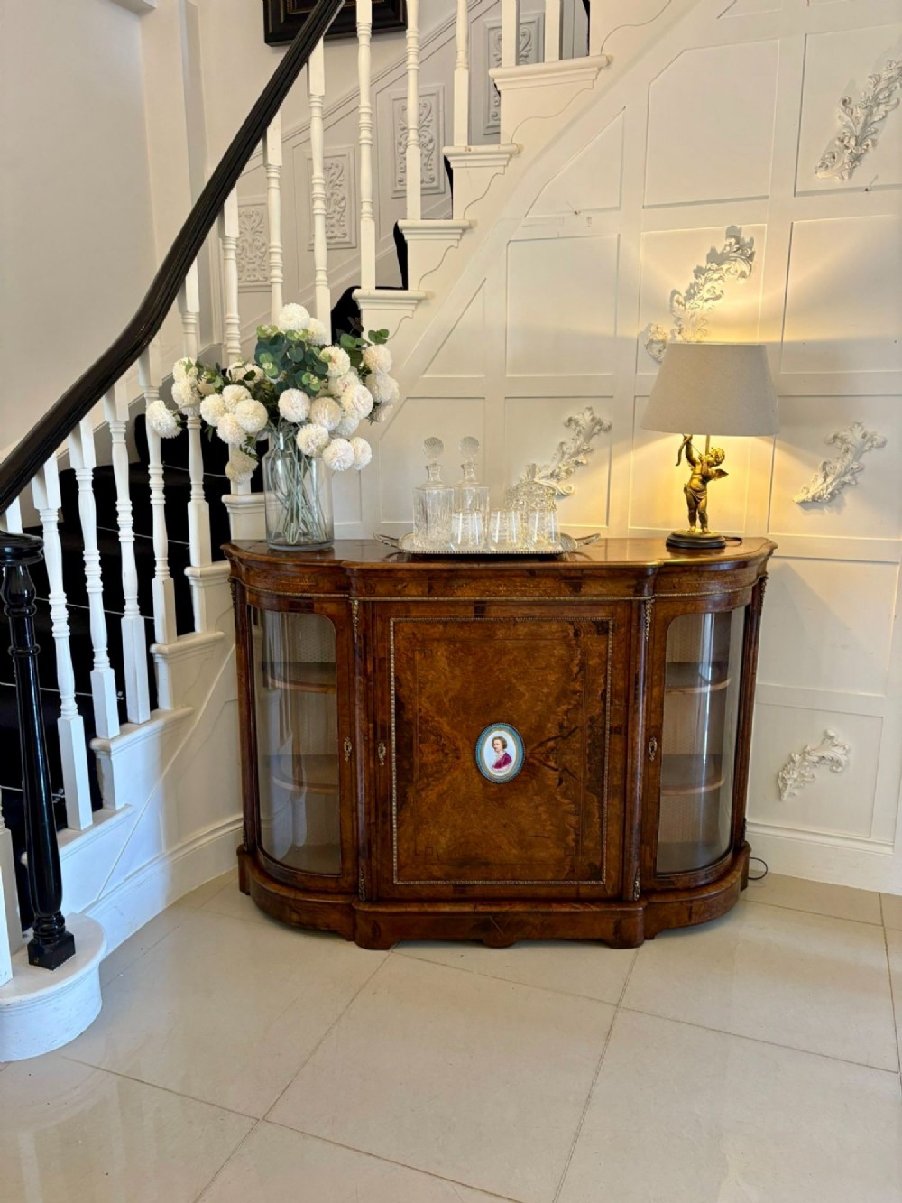 A Victorian burr walnut credenza featuring a central door with a hand-painted porcelain portrait plaque flanked by two curved glass display cupboards and gilt-brass mounts. View III