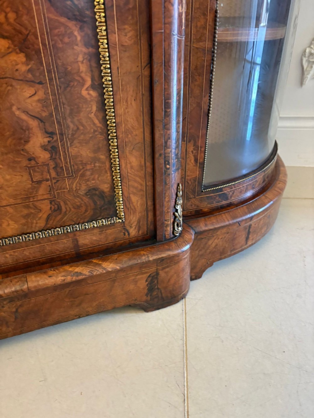 A Victorian burr walnut credenza featuring a central door with a hand-painted porcelain portrait plaque flanked by two curved glass display cupboards and gilt-brass mounts. View IV