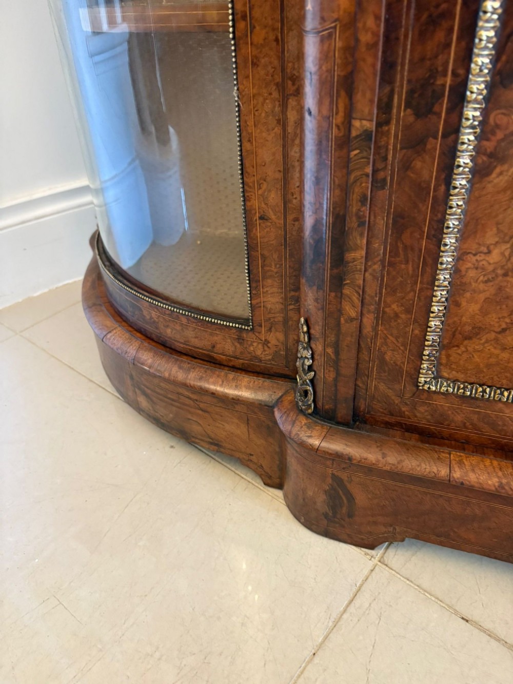 A Victorian burr walnut credenza featuring a central door with a hand-painted porcelain portrait plaque flanked by two curved glass display cupboards and gilt-brass mounts. View V