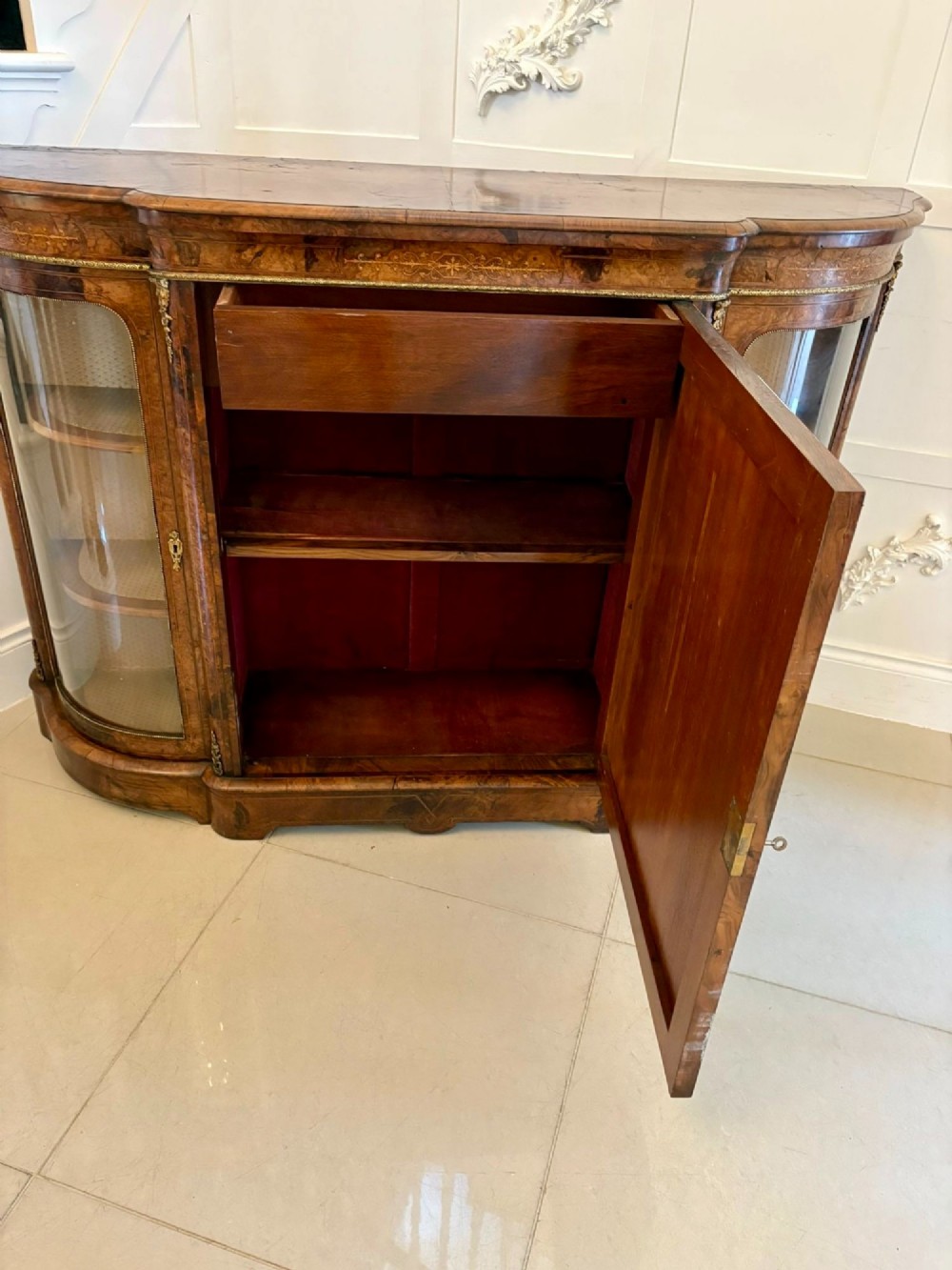 A Victorian burr walnut credenza featuring a central door with a hand-painted porcelain portrait plaque flanked by two curved glass display cupboards and gilt-brass mounts. View VIII