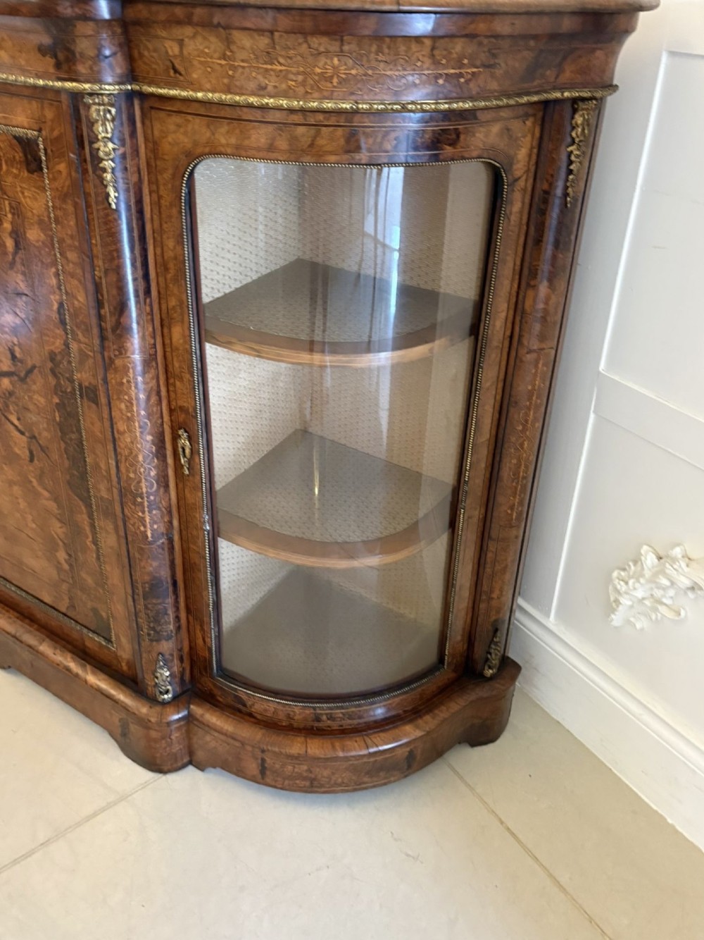 A Victorian burr walnut credenza featuring a central door with a hand-painted porcelain portrait plaque flanked by two curved glass display cupboards and gilt-brass mounts. View IX
