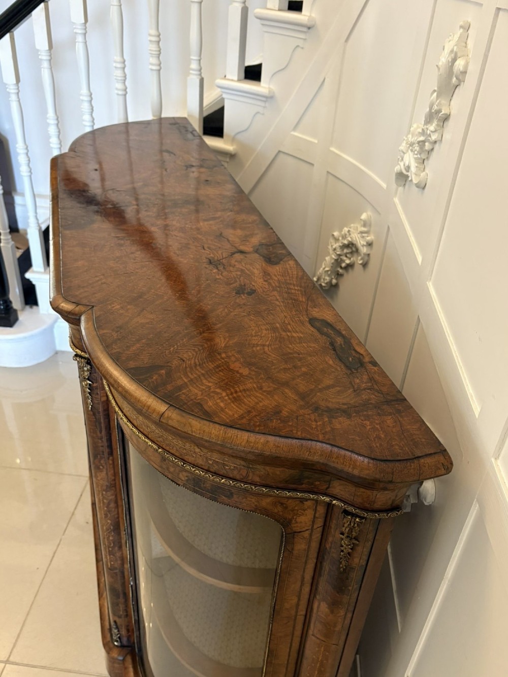 A Victorian burr walnut credenza featuring a central door with a hand-painted porcelain portrait plaque flanked by two curved glass display cupboards and gilt-brass mounts. View XI