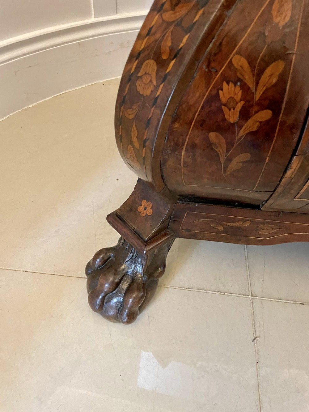 An 18th-century burr walnut bombe bureau featuring floral marquetry inlay, three curved drawers with brass handles, a slant top, and carved feet. View XI