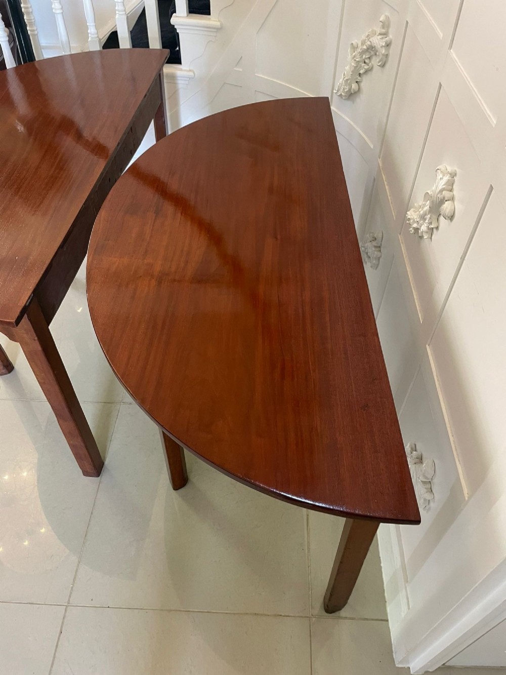 A pair of George III mahogany demi-lune console tables with polished semi-circular tops and straight tapered legs. View IV