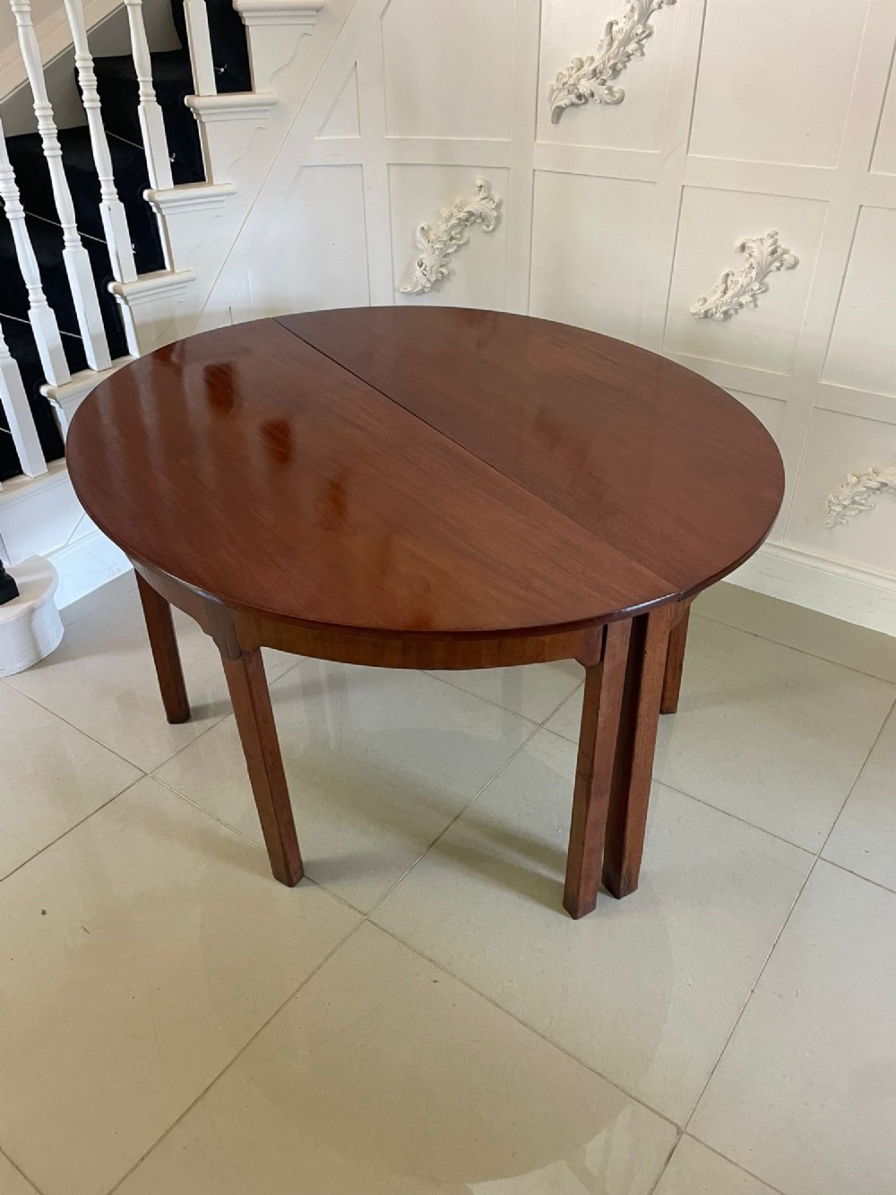 A pair of George III mahogany demi-lune console tables with polished semi-circular tops and straight tapered legs. View VI