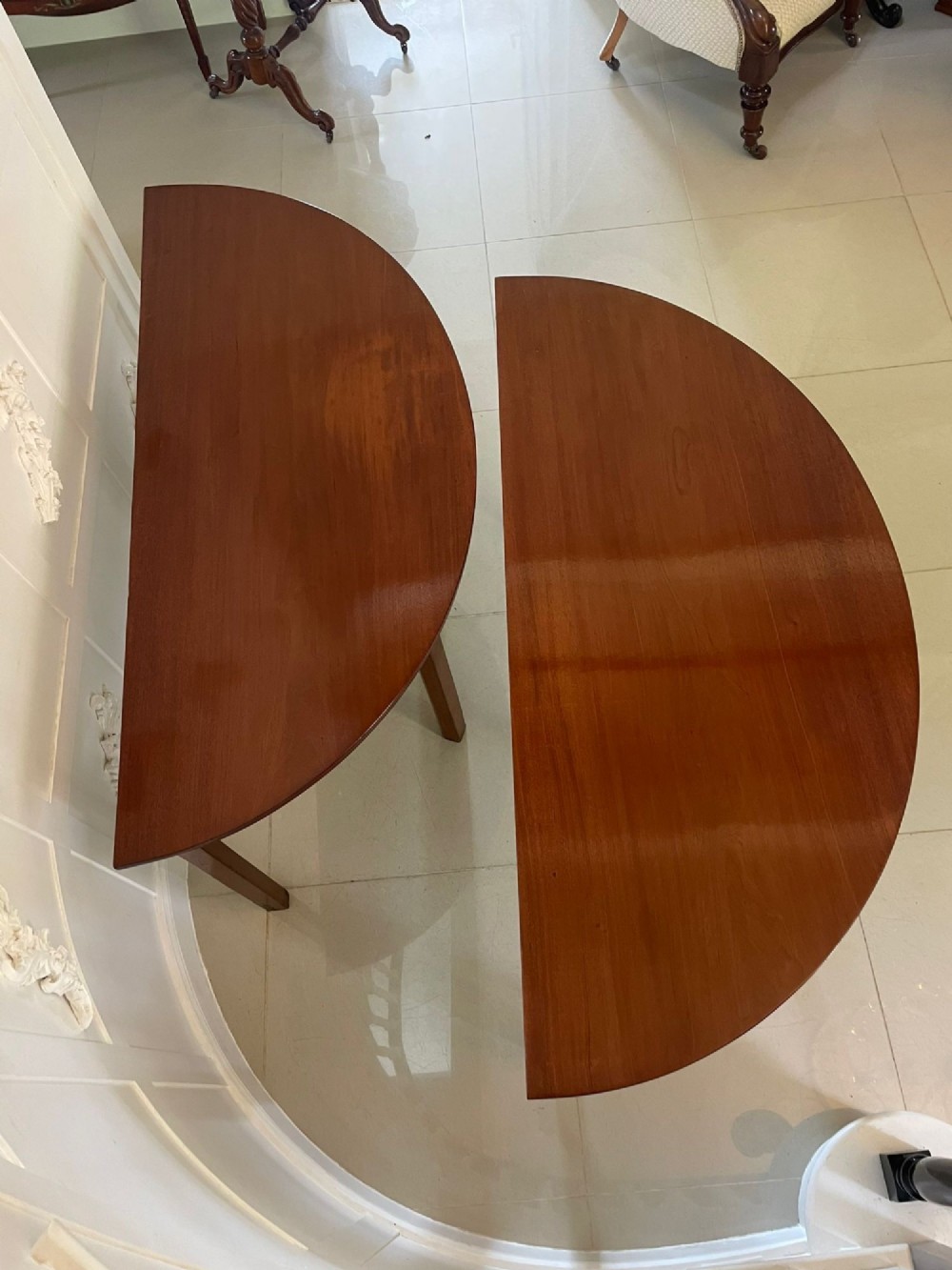 A pair of George III mahogany demi-lune console tables with polished semi-circular tops and straight tapered legs. View VII