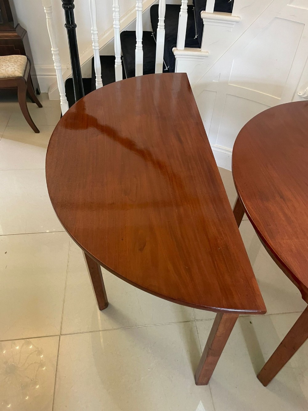 A pair of George III mahogany demi-lune console tables with polished semi-circular tops and straight tapered legs. View VIII