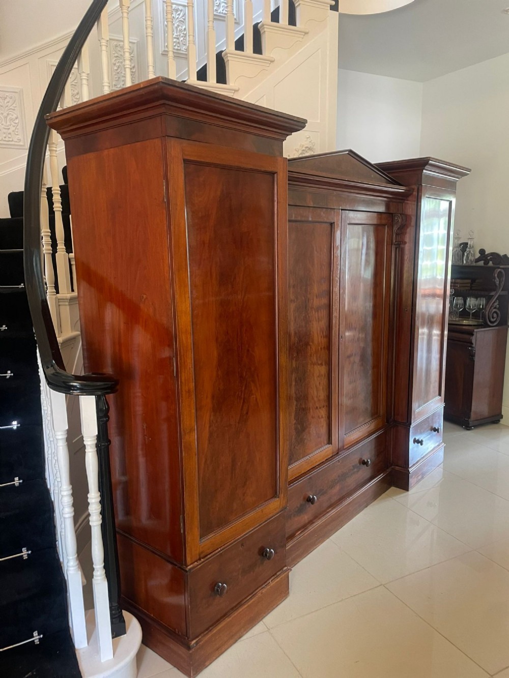 A large Victorian breakfront mahogany four-door wardrobe featuring figured wood veneer panels and lower base drawers. View II