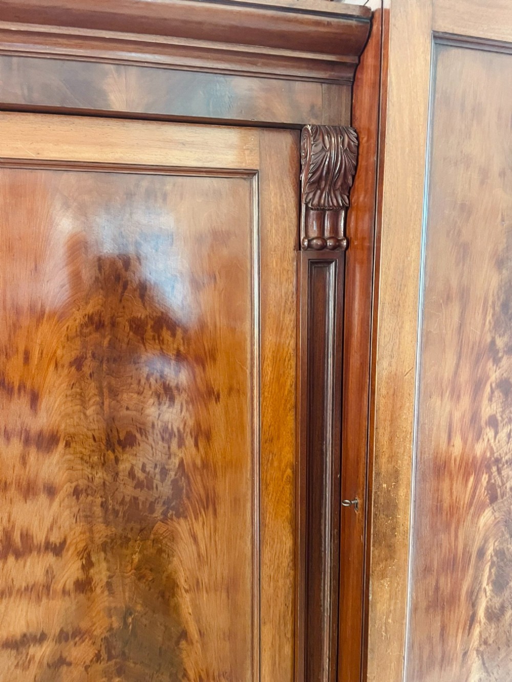A large Victorian breakfront mahogany four-door wardrobe featuring figured wood veneer panels and lower base drawers. View III