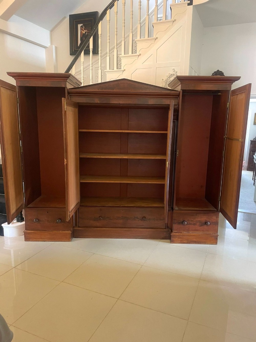 A large Victorian breakfront mahogany four-door wardrobe featuring figured wood veneer panels and lower base drawers. View IV