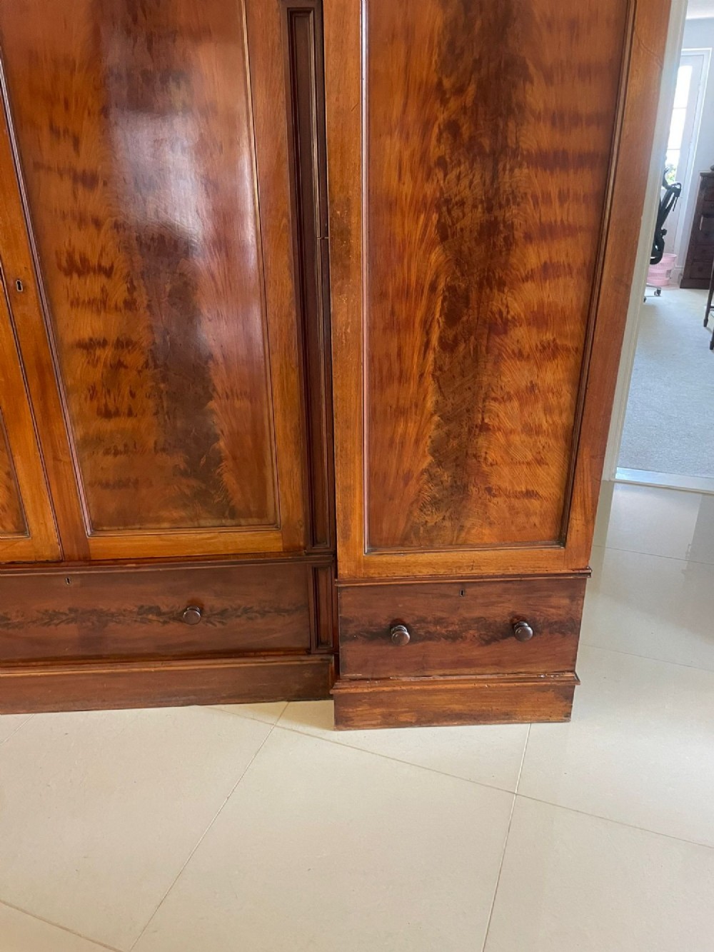 A large Victorian breakfront mahogany four-door wardrobe featuring figured wood veneer panels and lower base drawers. View V