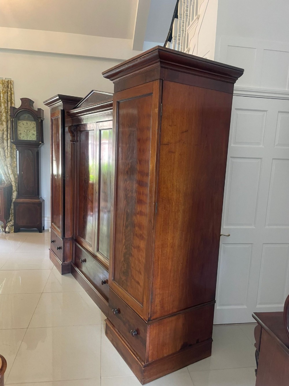 A large Victorian breakfront mahogany four-door wardrobe featuring figured wood veneer panels and lower base drawers. View VI