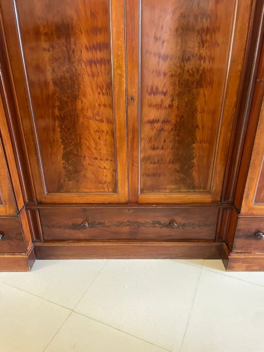A large Victorian breakfront mahogany four-door wardrobe featuring figured wood veneer panels and lower base drawers. View VII
