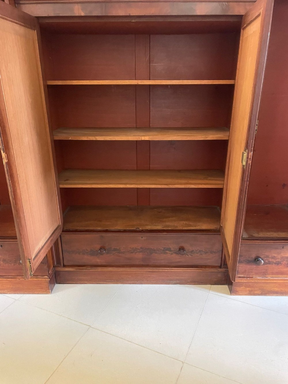 A large Victorian breakfront mahogany four-door wardrobe featuring figured wood veneer panels and lower base drawers. View X