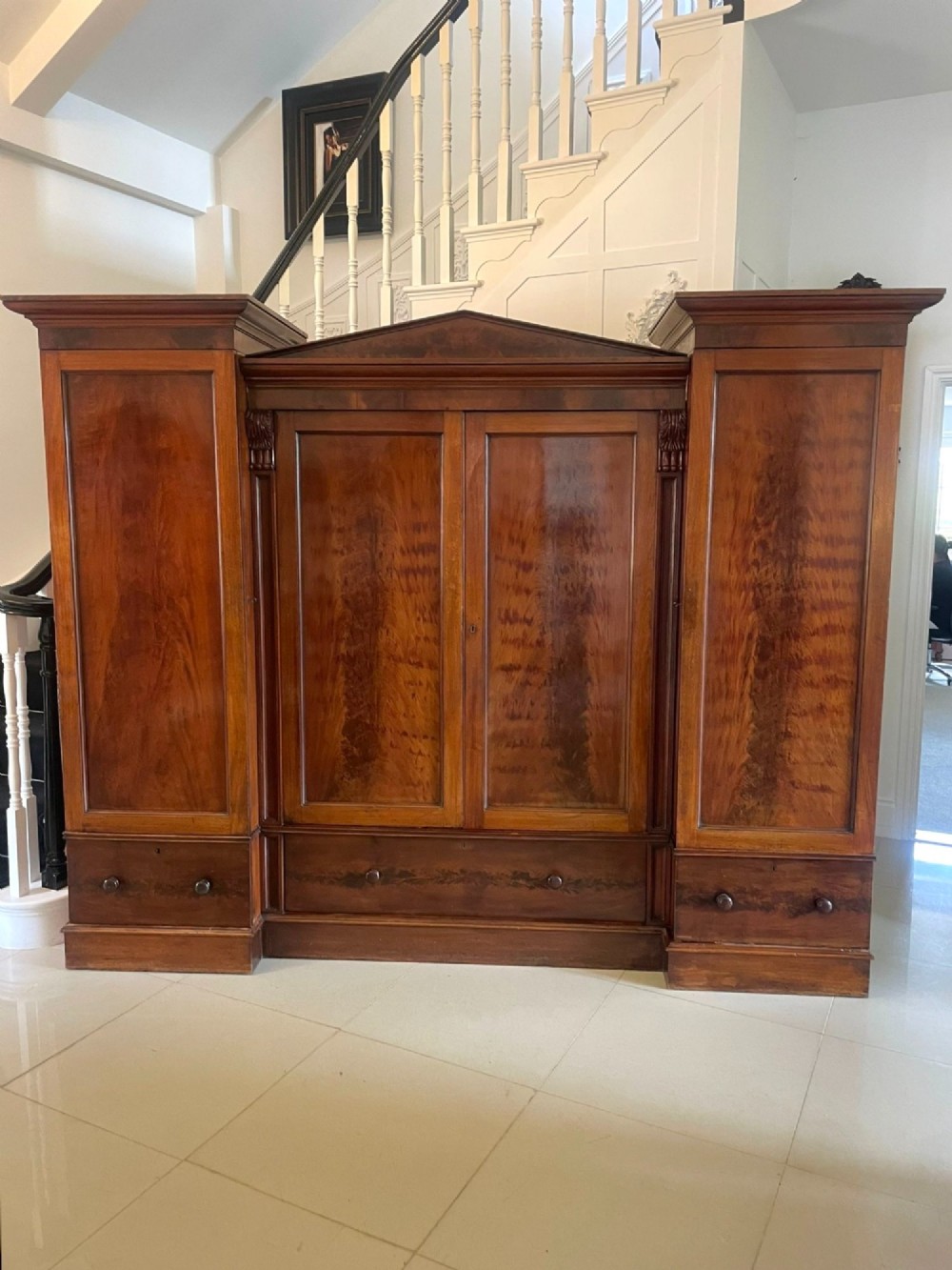 A large Victorian breakfront mahogany four-door wardrobe featuring figured wood veneer panels and lower base drawers.