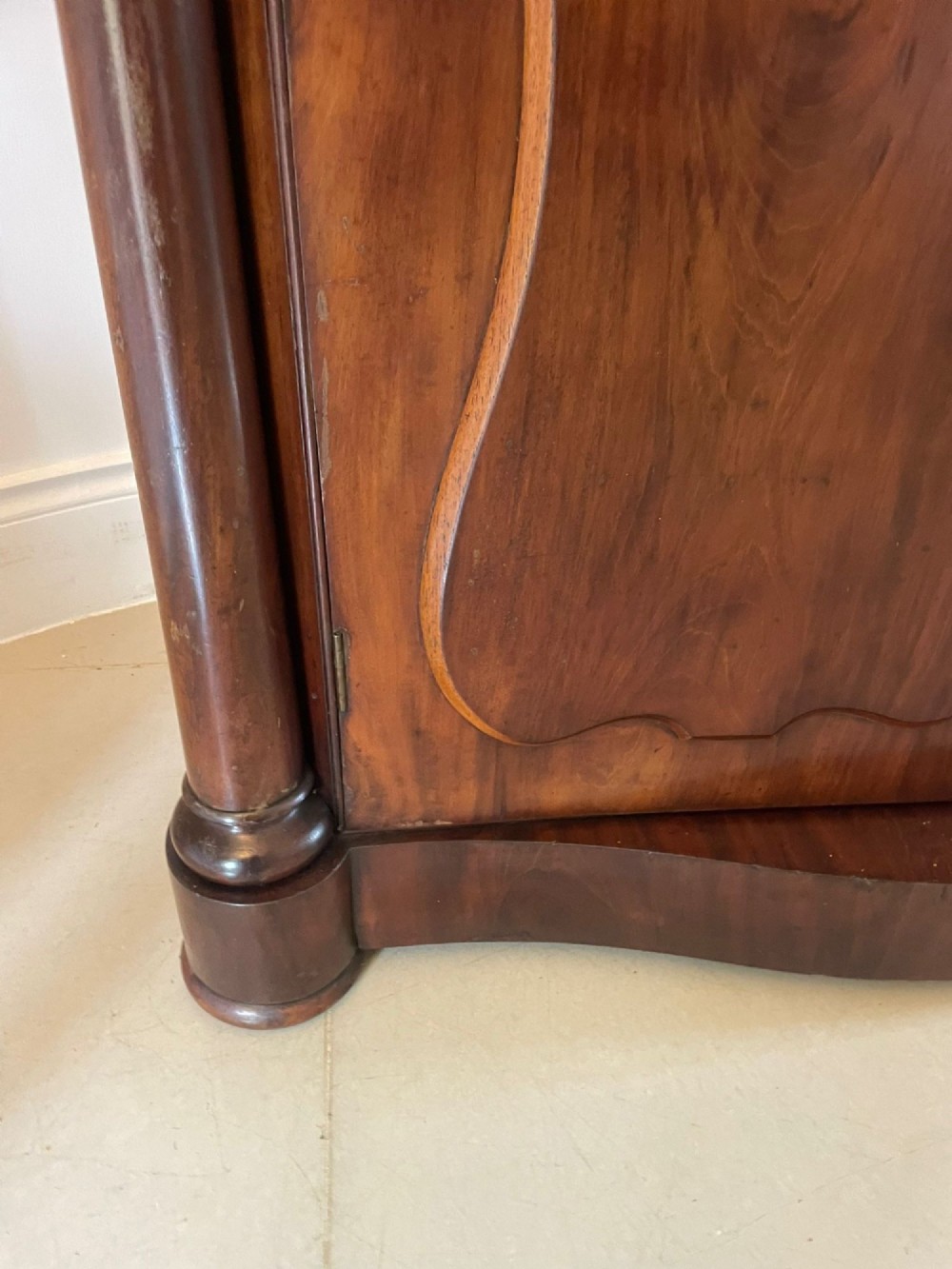 A Victorian mahogany glazed bookcase featuring two upper arched glass doors flanked by turned columns above a curved two-door cupboard base. View X