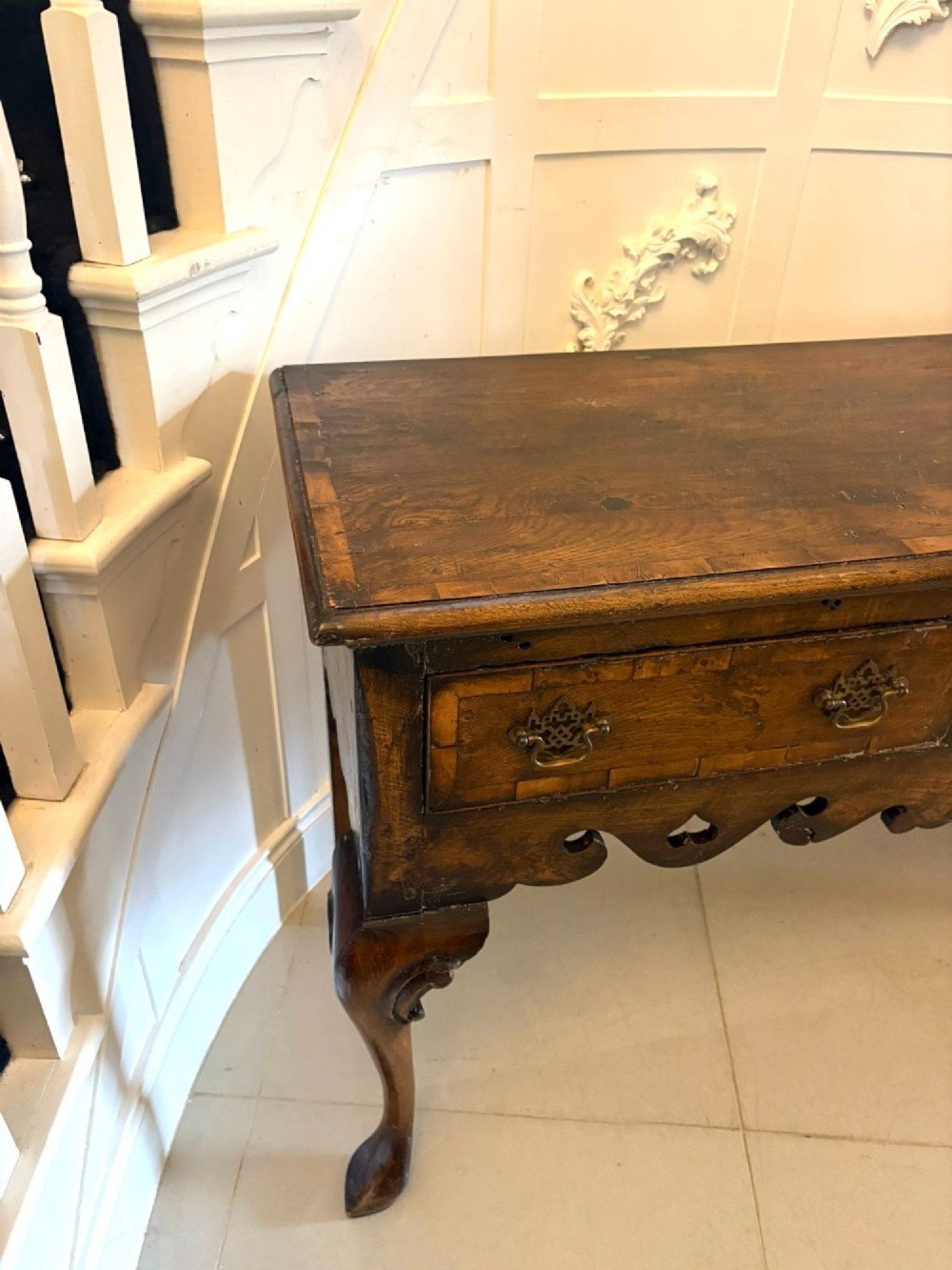 A dark brown oak Georgian style dresser base featuring three drawers with brass drop handles, a decorative scalloped apron, and front cabriole legs. View V