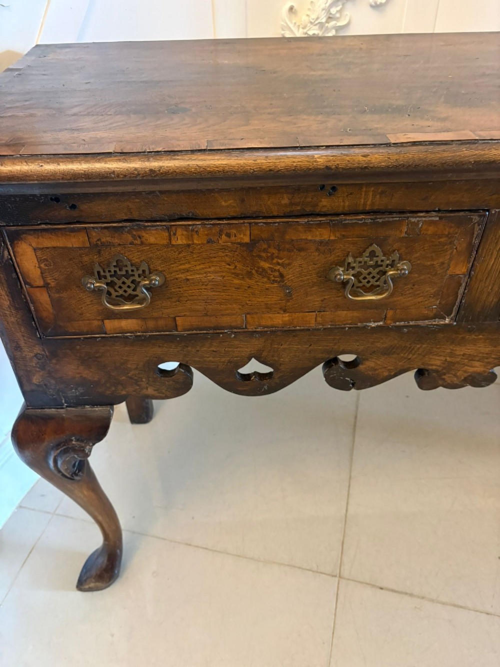A dark brown oak Georgian style dresser base featuring three drawers with brass drop handles, a decorative scalloped apron, and front cabriole legs. View VI