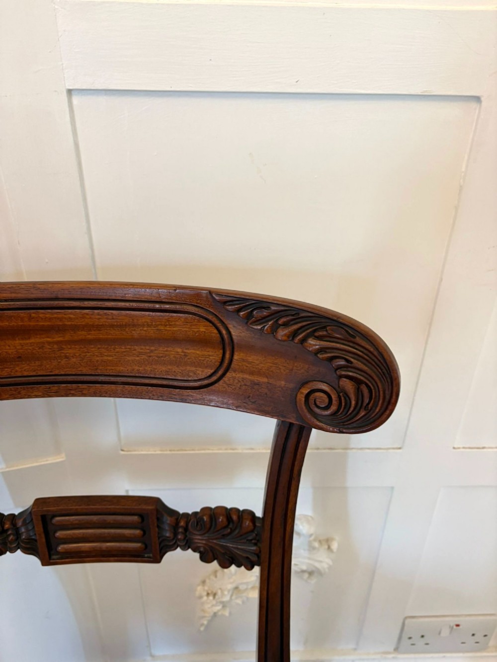 A set of four antique Regency mahogany dining chairs with carved top rails, reeded turned front legs, and blue and white striped upholstered seats. View XI