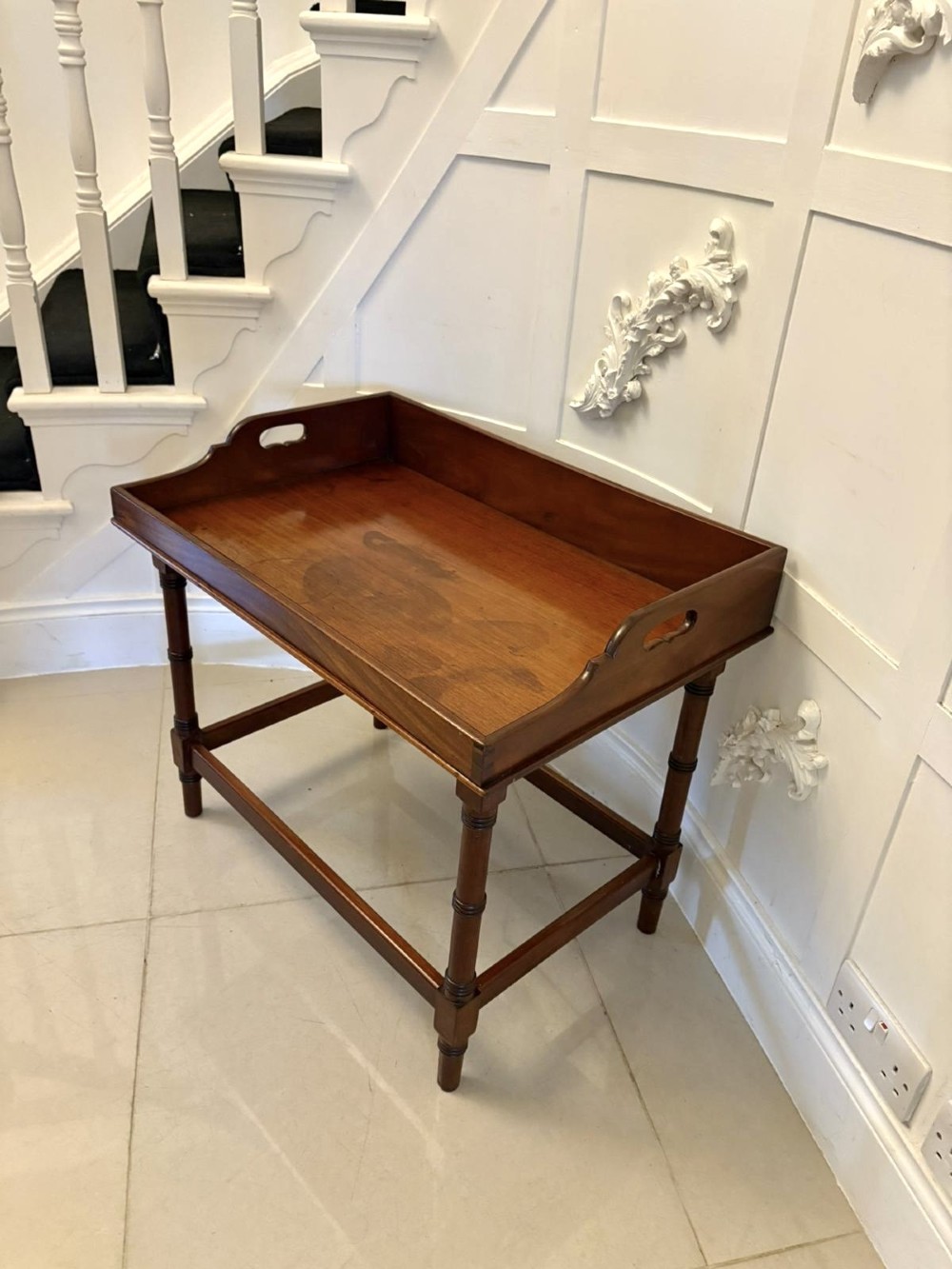 A dark mahogany tray-top occasional table featuring a raised gallery with carved carrying handles, turned legs, and stretchers. View VII