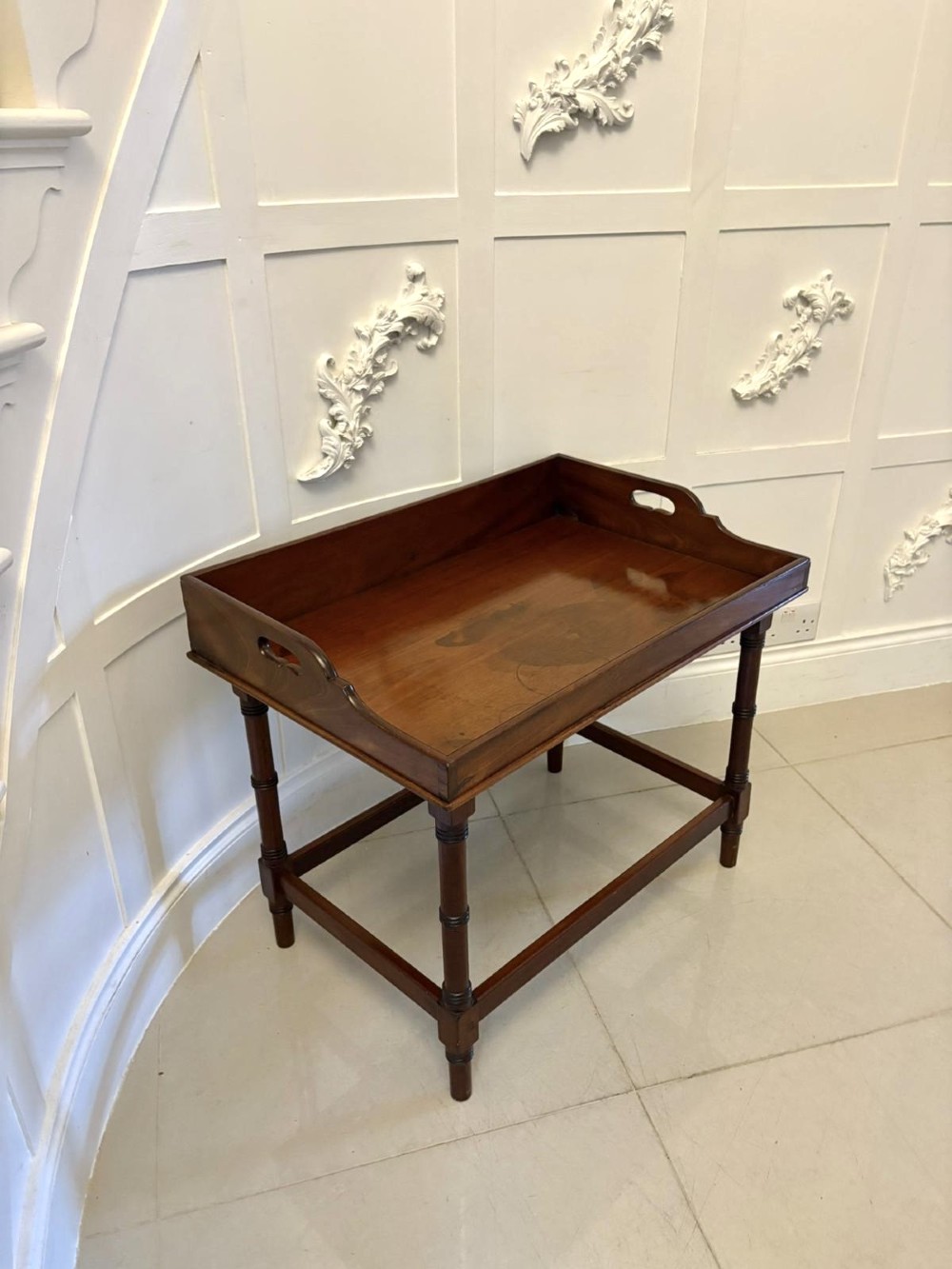 A dark mahogany tray-top occasional table featuring a raised gallery with carved carrying handles, turned legs, and stretchers. View IX