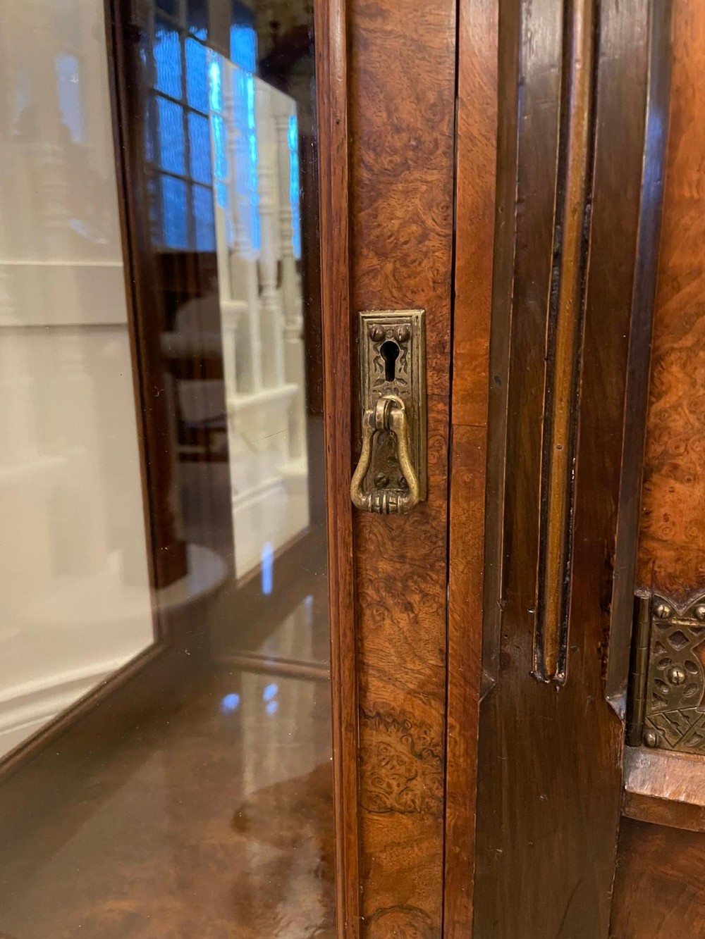 An antique Victorian burr walnut credenza featuring glazed flank doors, central geometric inlaid doors, brass fittings, and turned support columns. View XI
