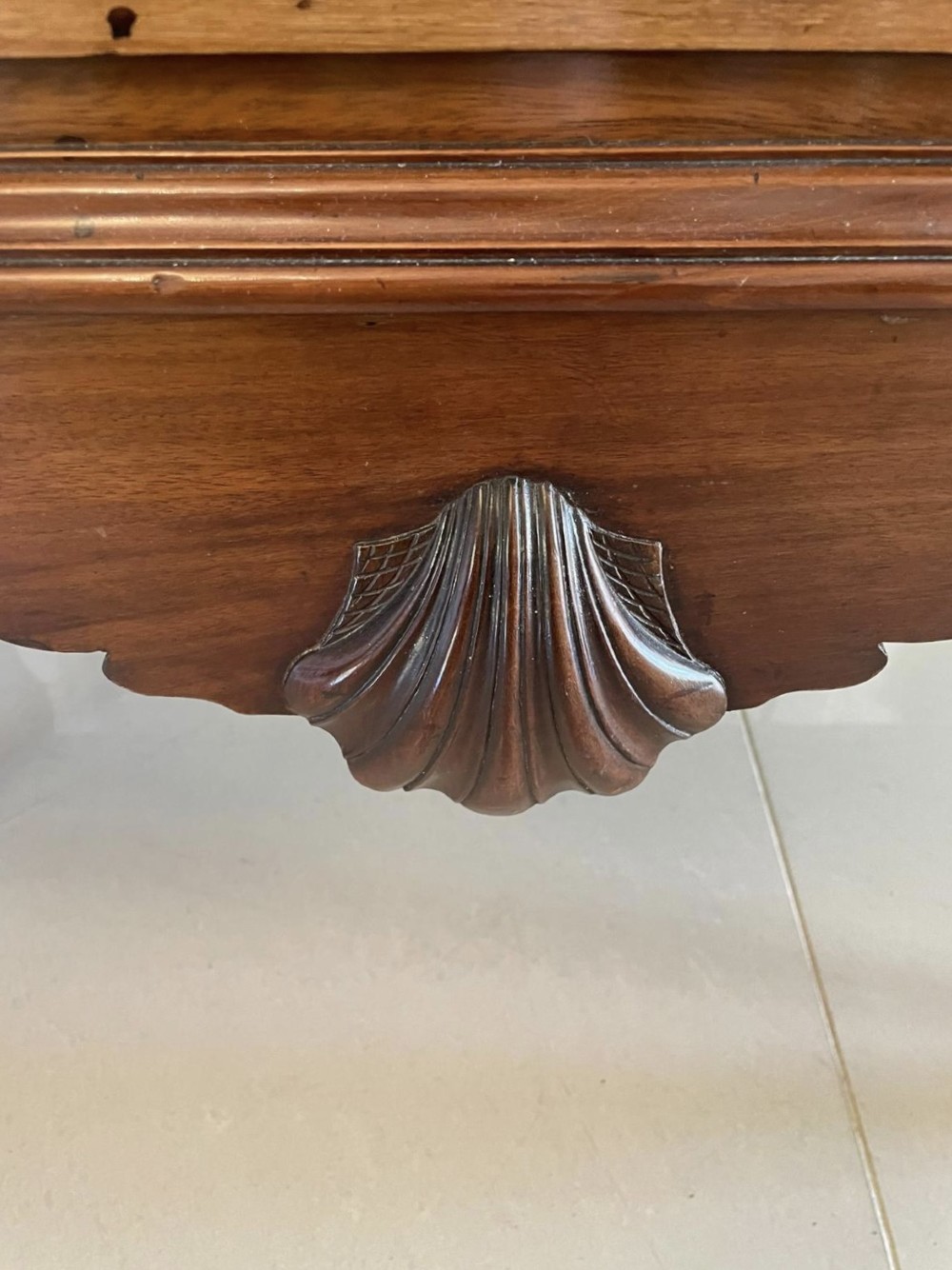 A George III mahogany chest on stand featuring two short over two long drawers, brass handles, a carved shell apron, and cabriole legs. View IV