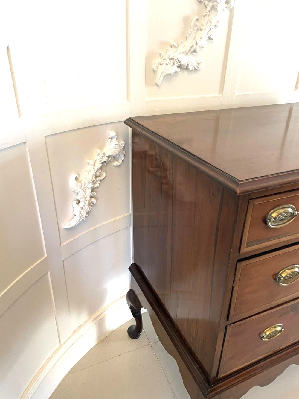 A George III mahogany chest on stand featuring two short over two long drawers, brass handles, a carved shell apron, and cabriole legs. View V