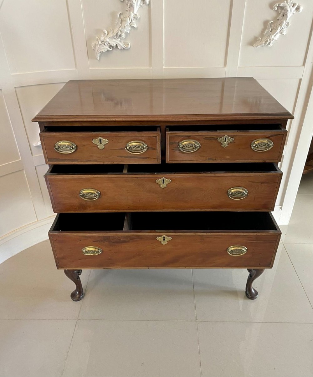A George III mahogany chest on stand featuring two short over two long drawers, brass handles, a carved shell apron, and cabriole legs. View VI