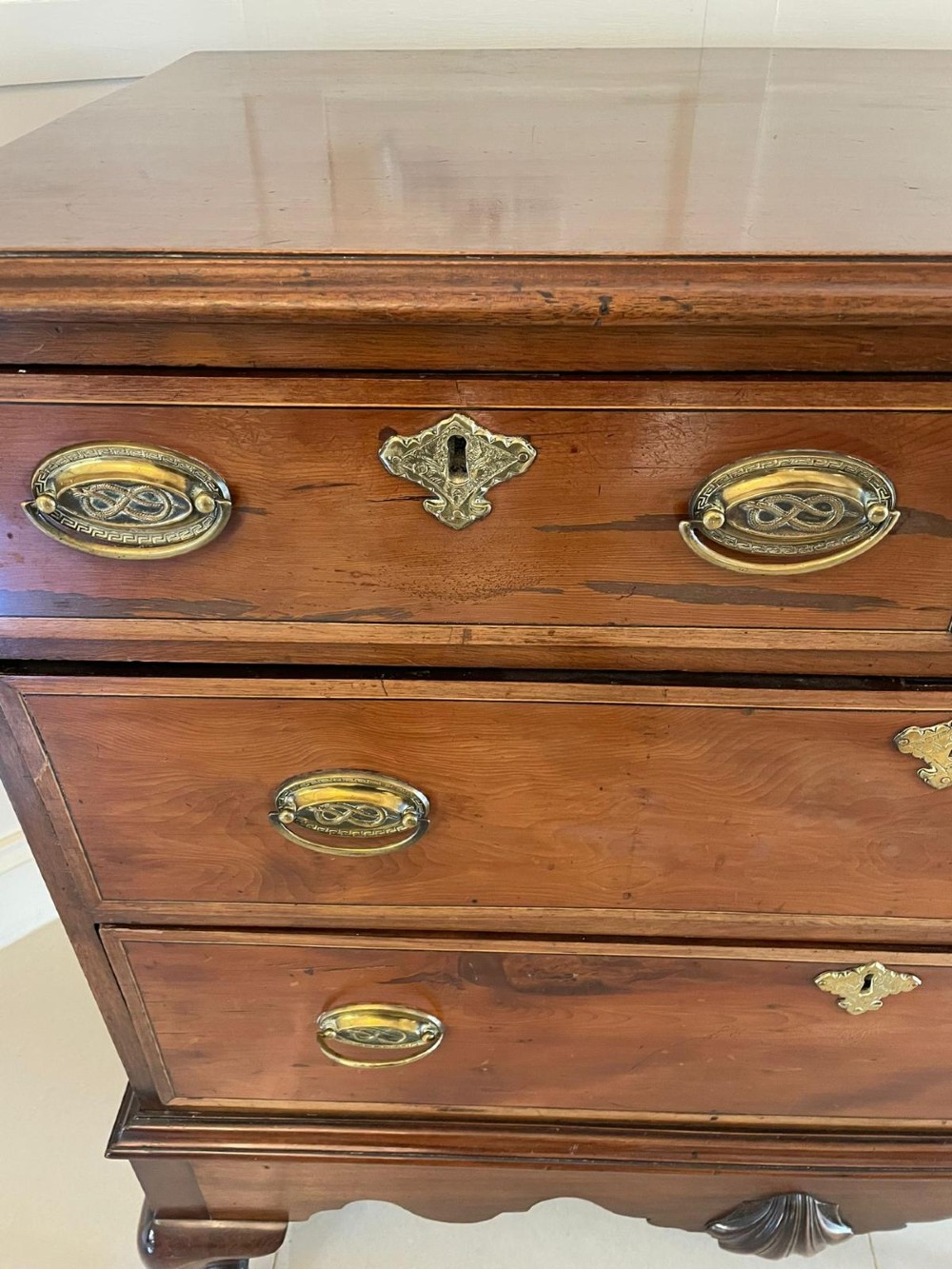 A George III mahogany chest on stand featuring two short over two long drawers, brass handles, a carved shell apron, and cabriole legs. View VII