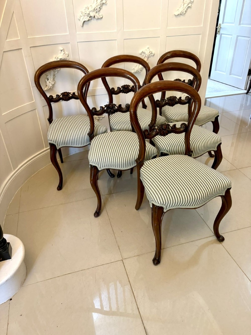 Set of six antique Victorian mahogany dining chairs featuring carved balloon backrests, cabriole front legs, and green-and-white striped fabric seats.