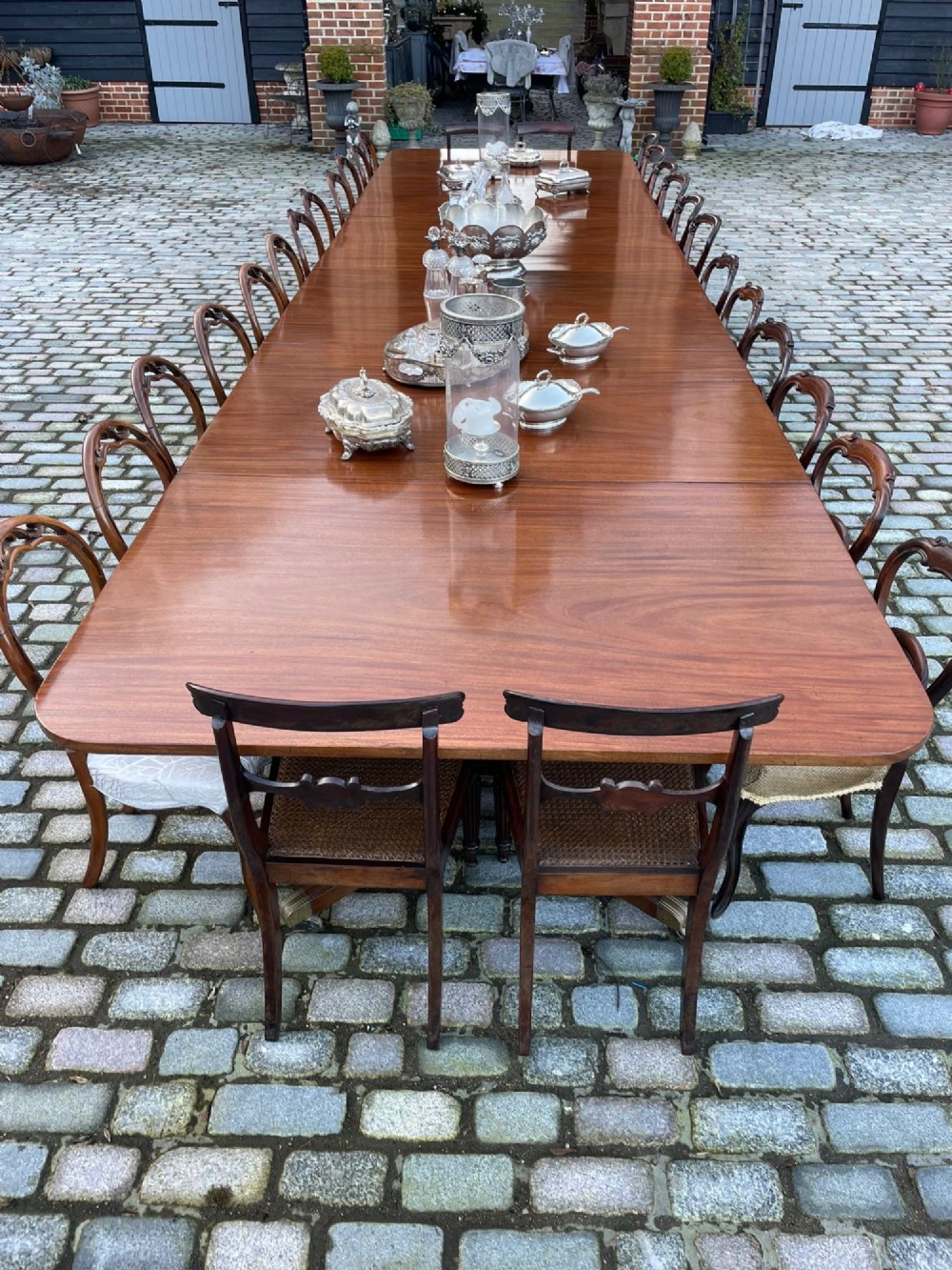 A long George III mahogany extending dining table with multiple pedestal bases resting on splayed reeded legs with brass castors. View VI