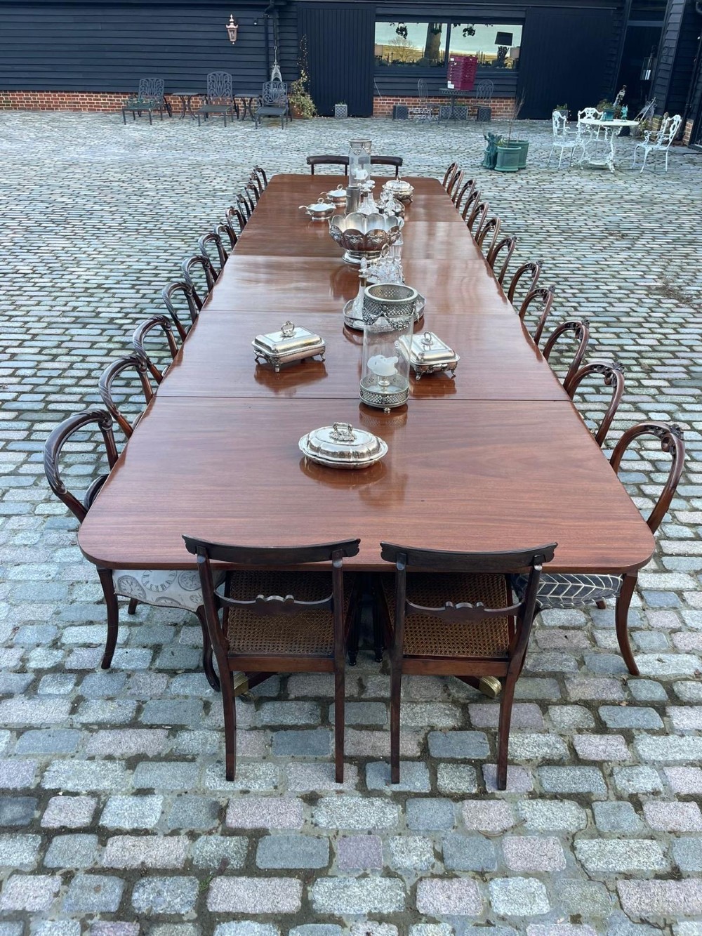 A long George III mahogany extending dining table with multiple pedestal bases resting on splayed reeded legs with brass castors. View VII