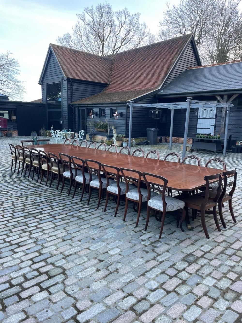 A long George III mahogany extending dining table with multiple pedestal bases resting on splayed reeded legs with brass castors. View X