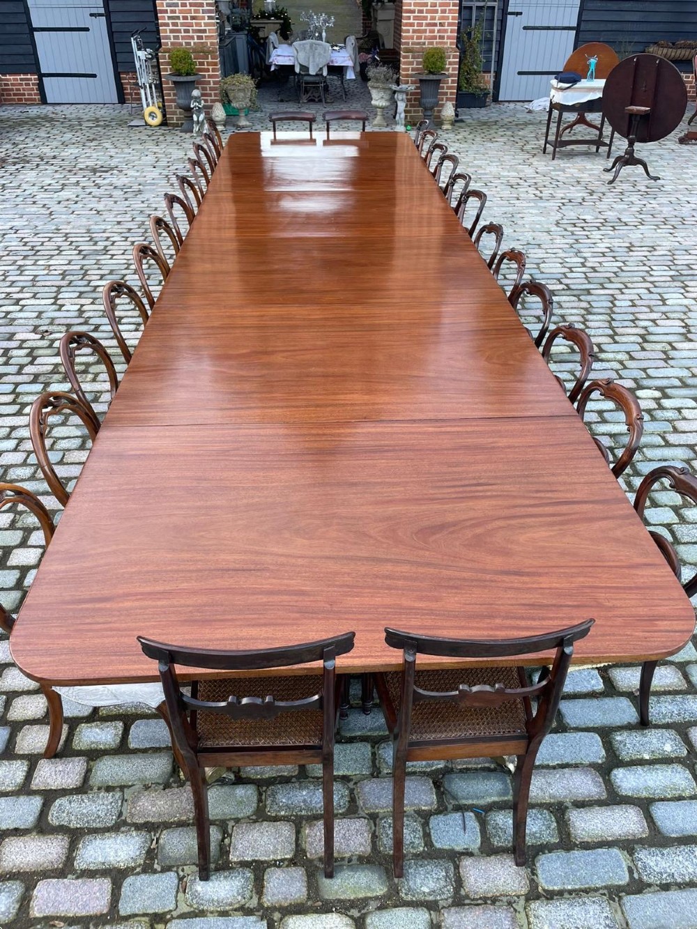 A long George III mahogany extending dining table with multiple pedestal bases resting on splayed reeded legs with brass castors. View XIII
