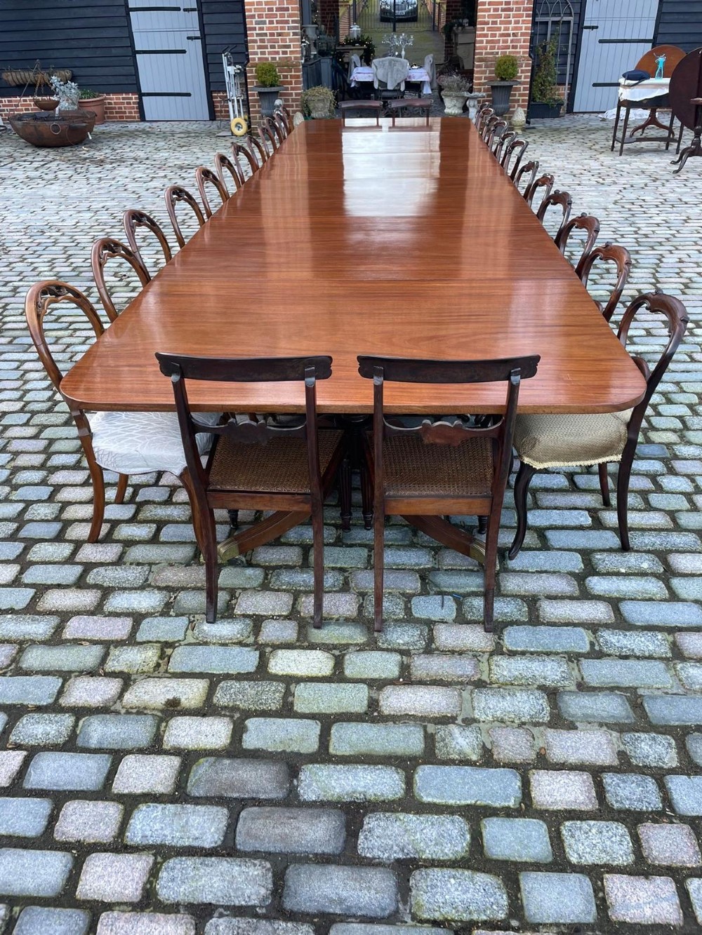 A long George III mahogany extending dining table with multiple pedestal bases resting on splayed reeded legs with brass castors. View XIV