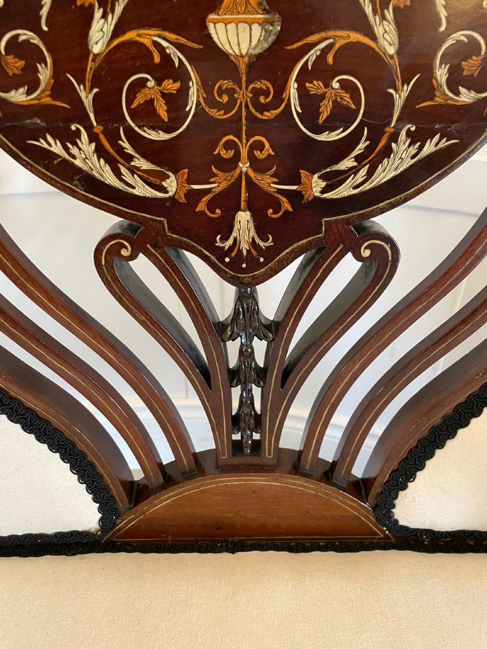 An antique Victorian mahogany settee featuring cream upholstered seating, curved arms, cabriole legs, and a central back splat with intricate floral wood inlay. View II