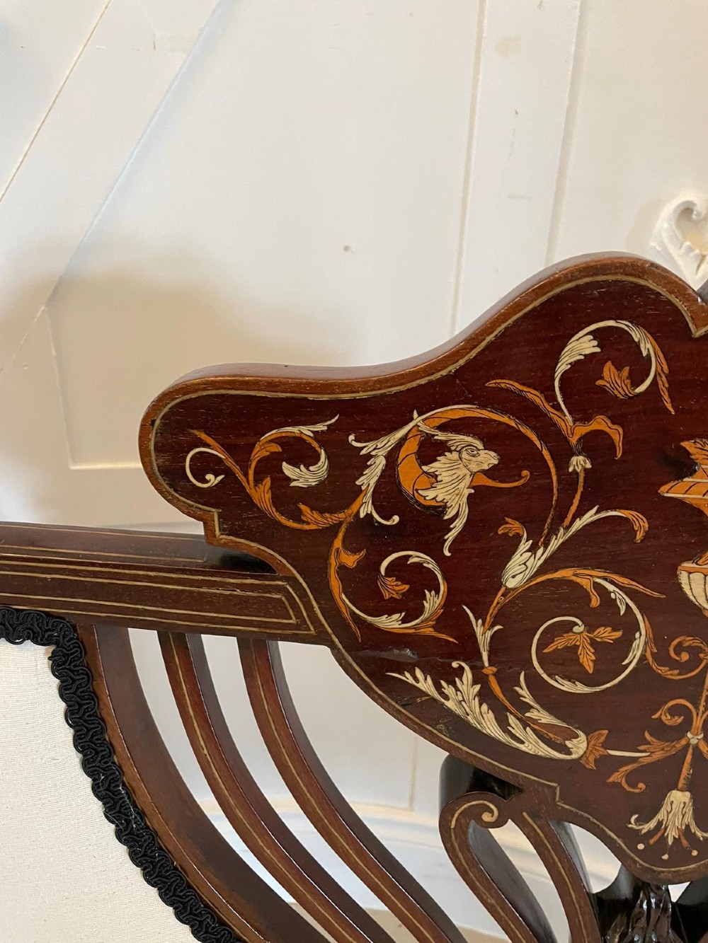 An antique Victorian mahogany settee featuring cream upholstered seating, curved arms, cabriole legs, and a central back splat with intricate floral wood inlay. View III