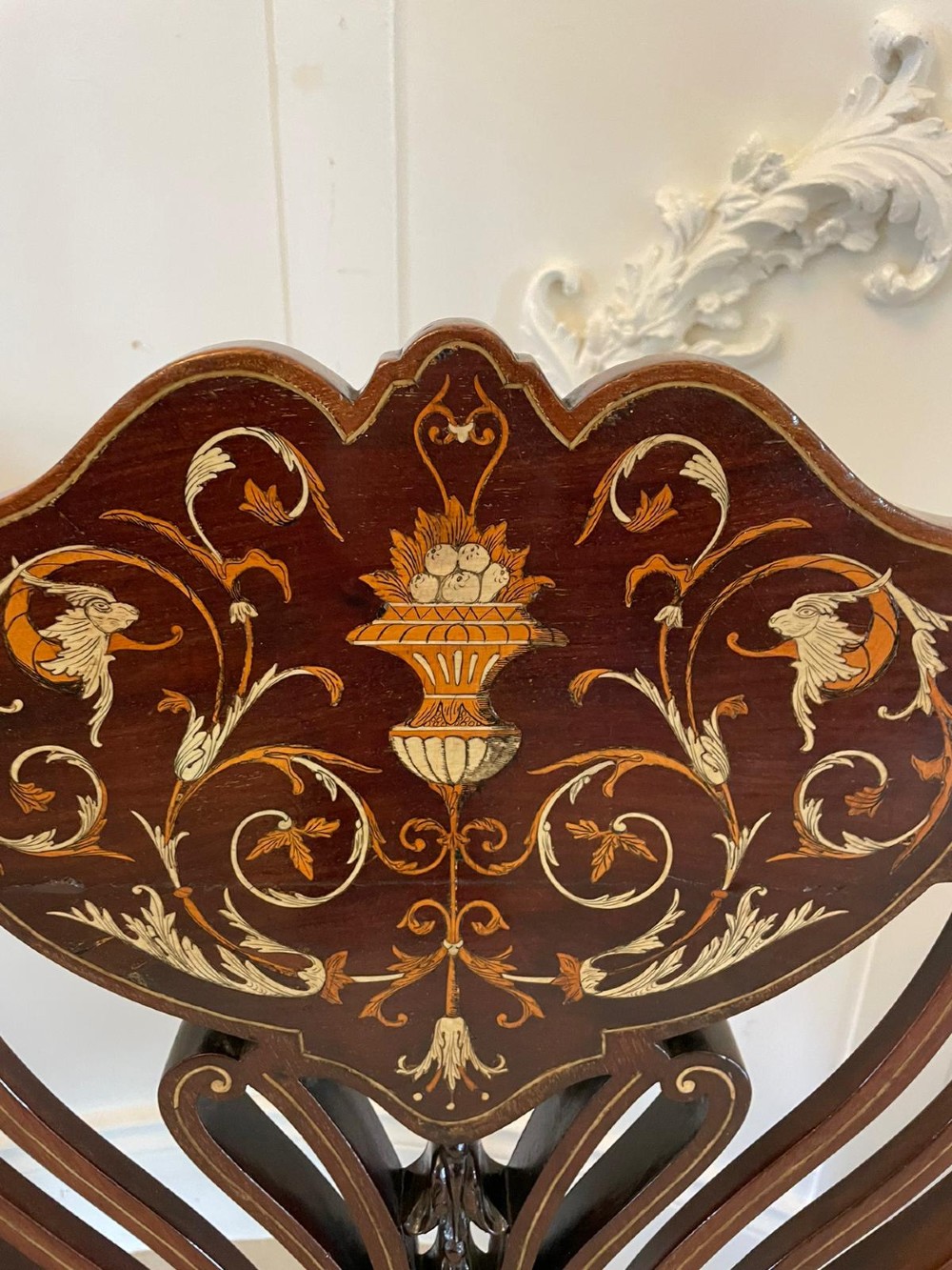 An antique Victorian mahogany settee featuring cream upholstered seating, curved arms, cabriole legs, and a central back splat with intricate floral wood inlay. View IV