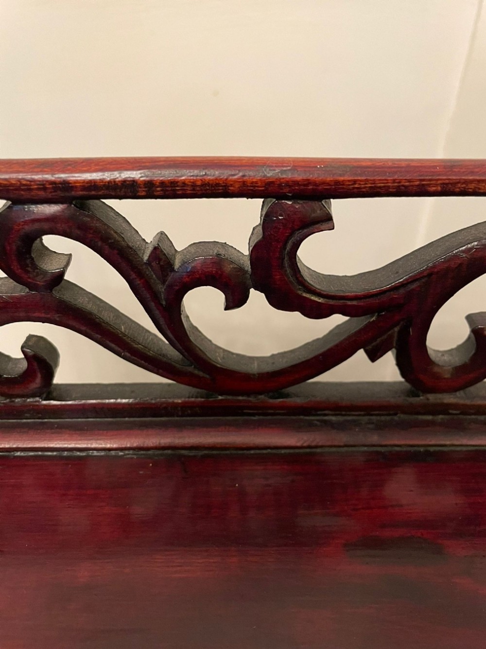 An antique dark reddish-brown Chinese hardwood display cabinet featuring asymmetrical open shelves, carved scrollwork galleries, and two small cupboards. View III