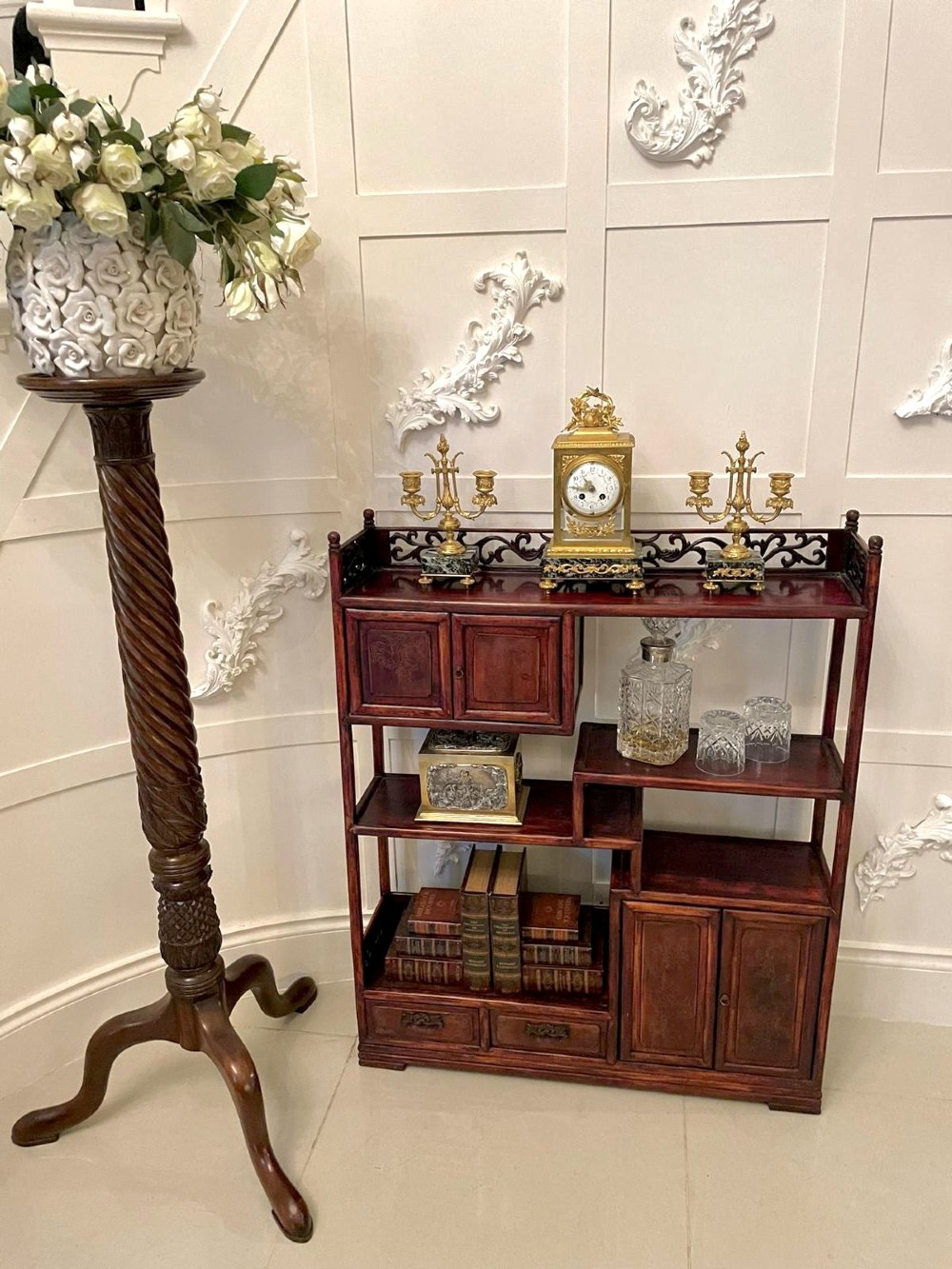 An antique dark reddish-brown Chinese hardwood display cabinet featuring asymmetrical open shelves, carved scrollwork galleries, and two small cupboards. View IV