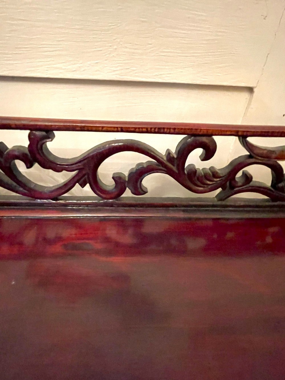 An antique dark reddish-brown Chinese hardwood display cabinet featuring asymmetrical open shelves, carved scrollwork galleries, and two small cupboards. View VIII