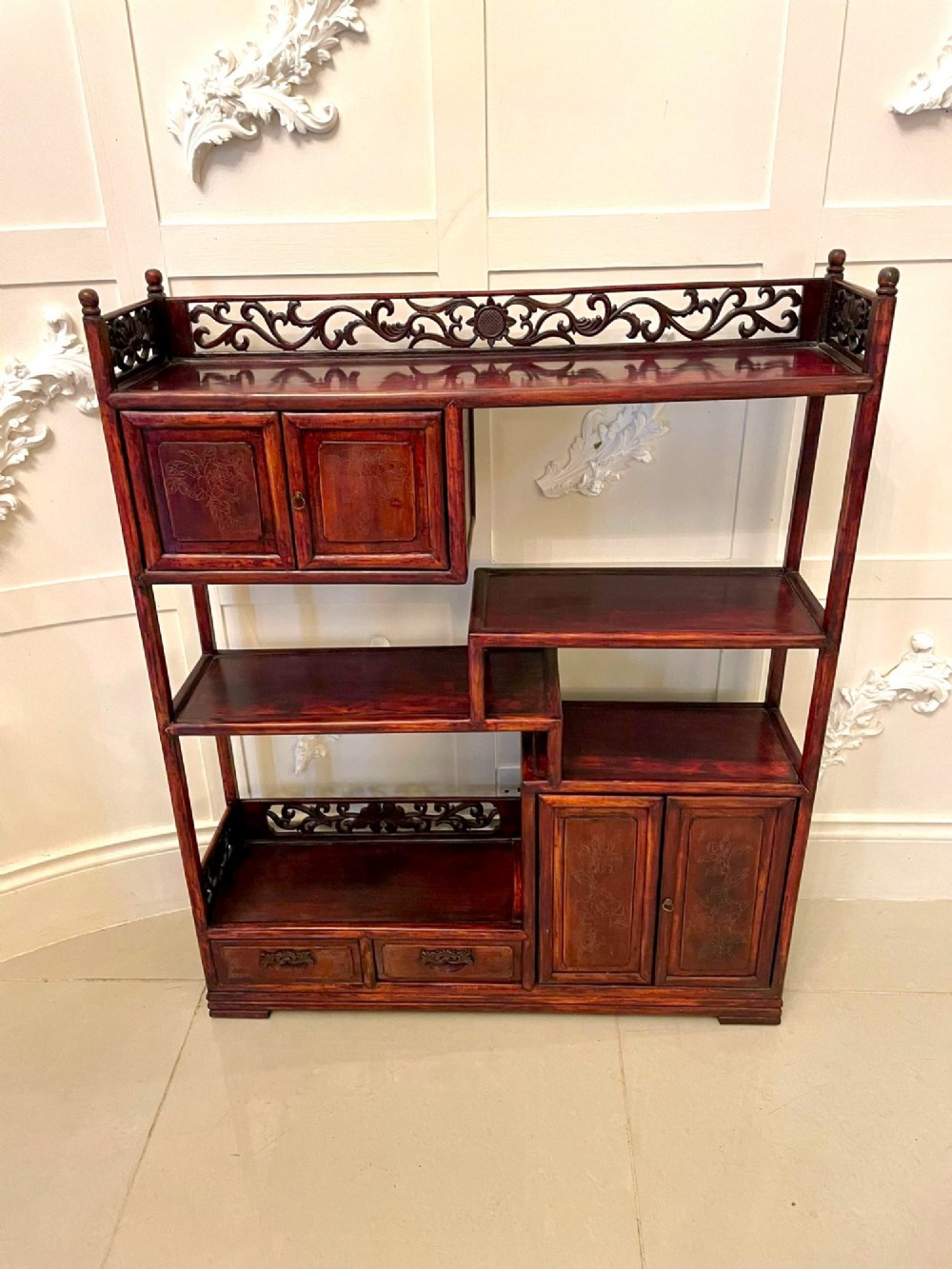 An antique dark reddish-brown Chinese hardwood display cabinet featuring asymmetrical open shelves, carved scrollwork galleries, and two small cupboards. View XIII