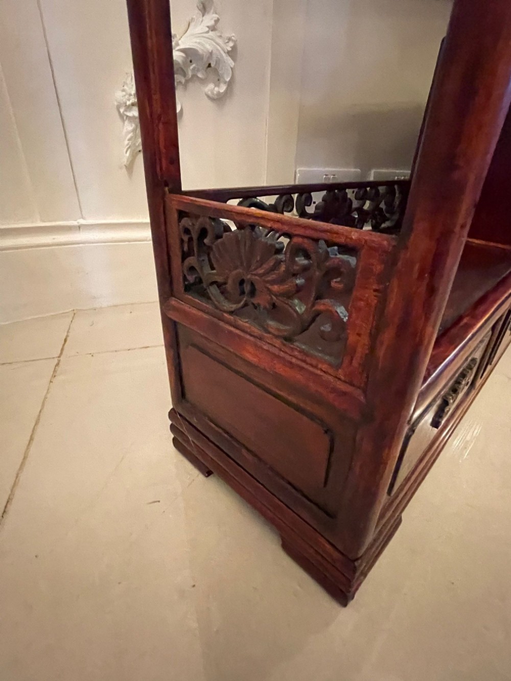 An antique dark reddish-brown Chinese hardwood display cabinet featuring asymmetrical open shelves, carved scrollwork galleries, and two small cupboards. View XIV