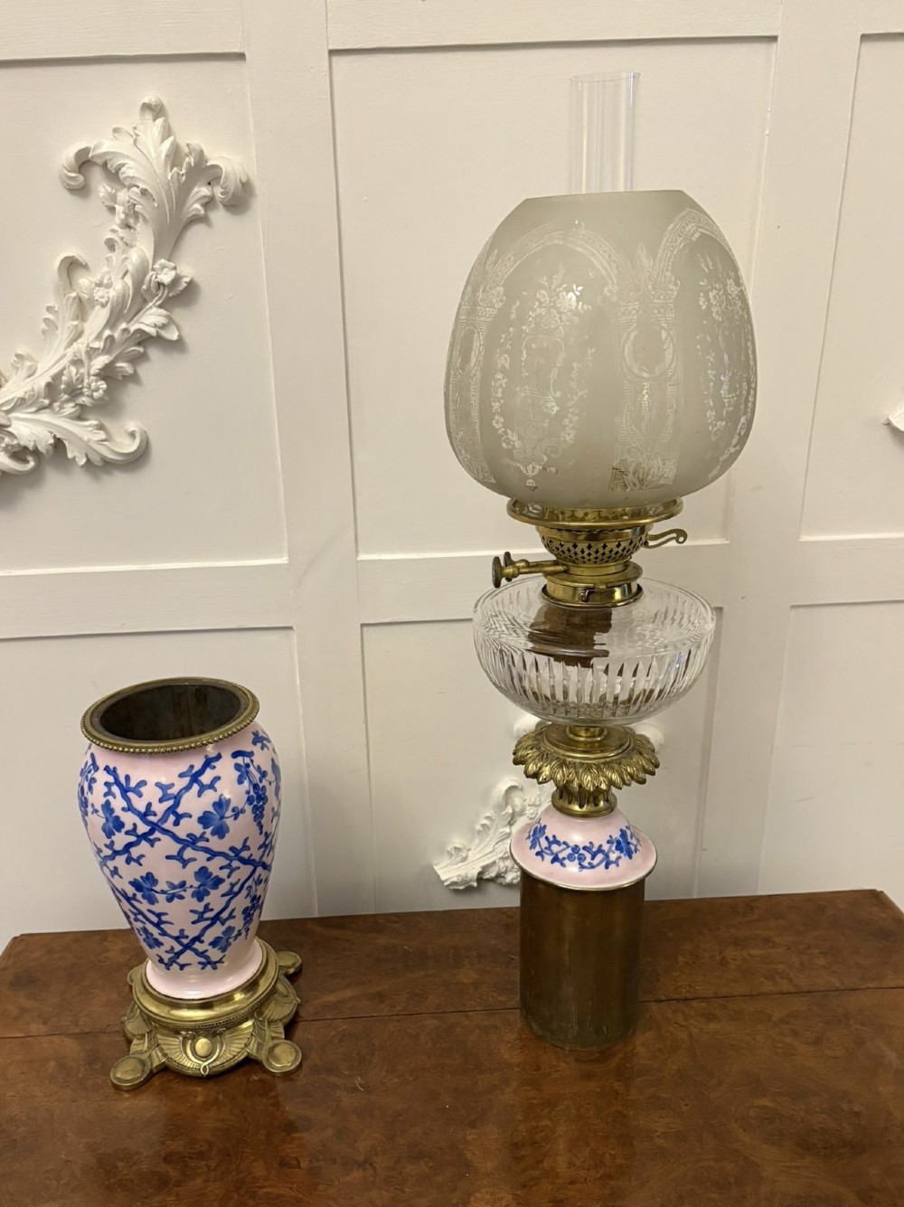 A tall Victorian oil lamp featuring a pink porcelain body with blue floral trellis decoration, a cast brass base, a cut glass reservoir, and an etched glass shade. View II