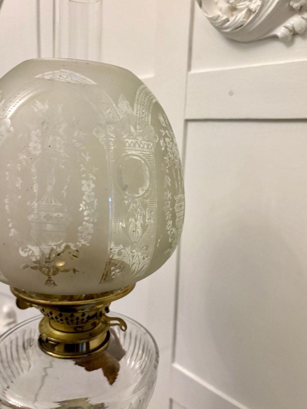 A tall Victorian oil lamp featuring a pink porcelain body with blue floral trellis decoration, a cast brass base, a cut glass reservoir, and an etched glass shade. View VII