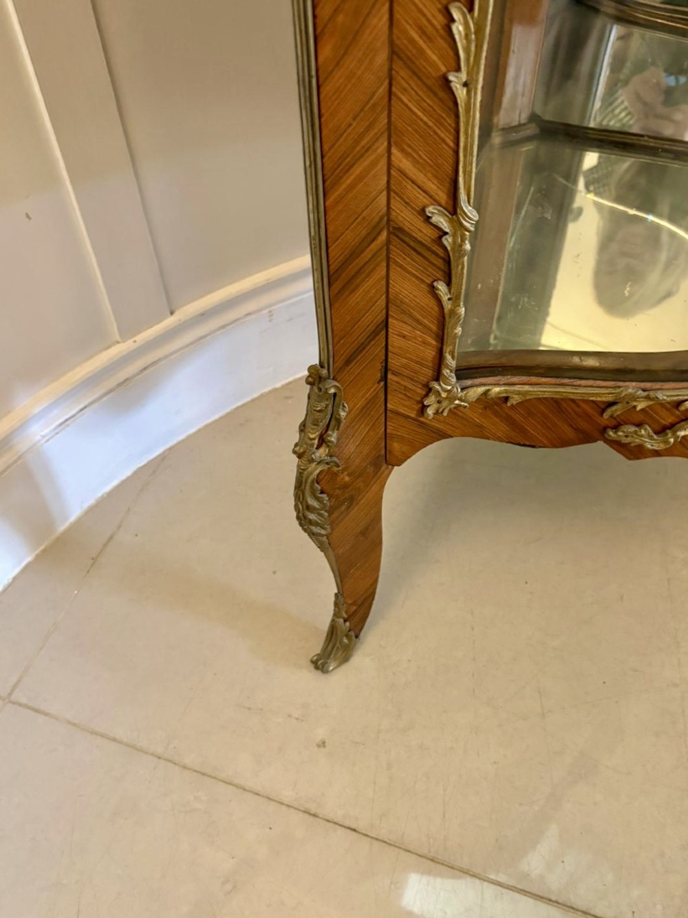 An antique French serpentine corner display cabinet crafted from kingwood with a marble top, curved glass door, internal glass shelves, and gilded ormolu mounts. View VI