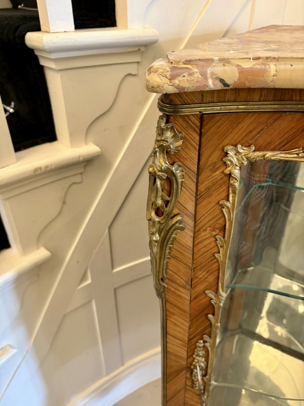 An antique French serpentine corner display cabinet crafted from kingwood with a marble top, curved glass door, internal glass shelves, and gilded ormolu mounts. View VII