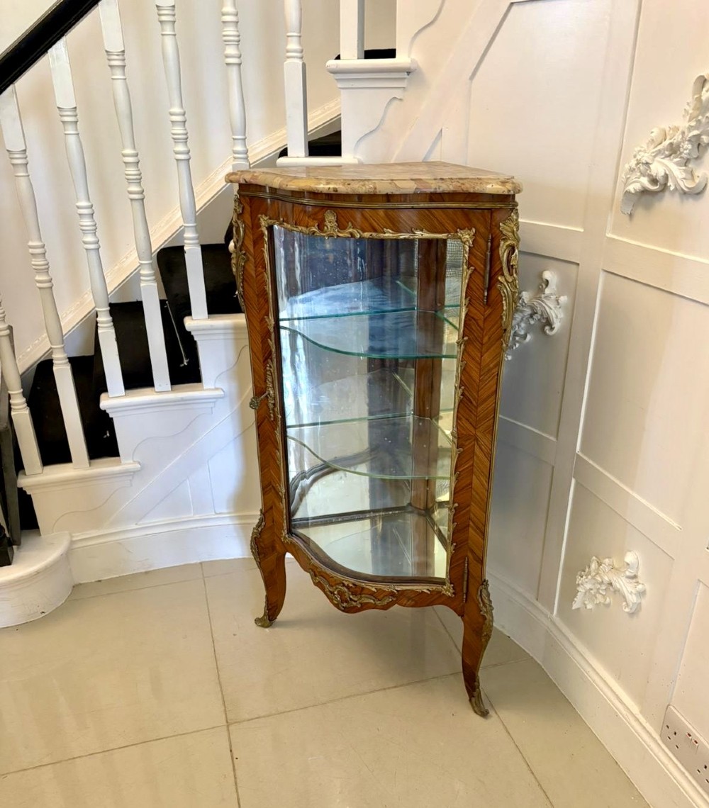 An antique French serpentine corner display cabinet crafted from kingwood with a marble top, curved glass door, internal glass shelves, and gilded ormolu mounts. View XI